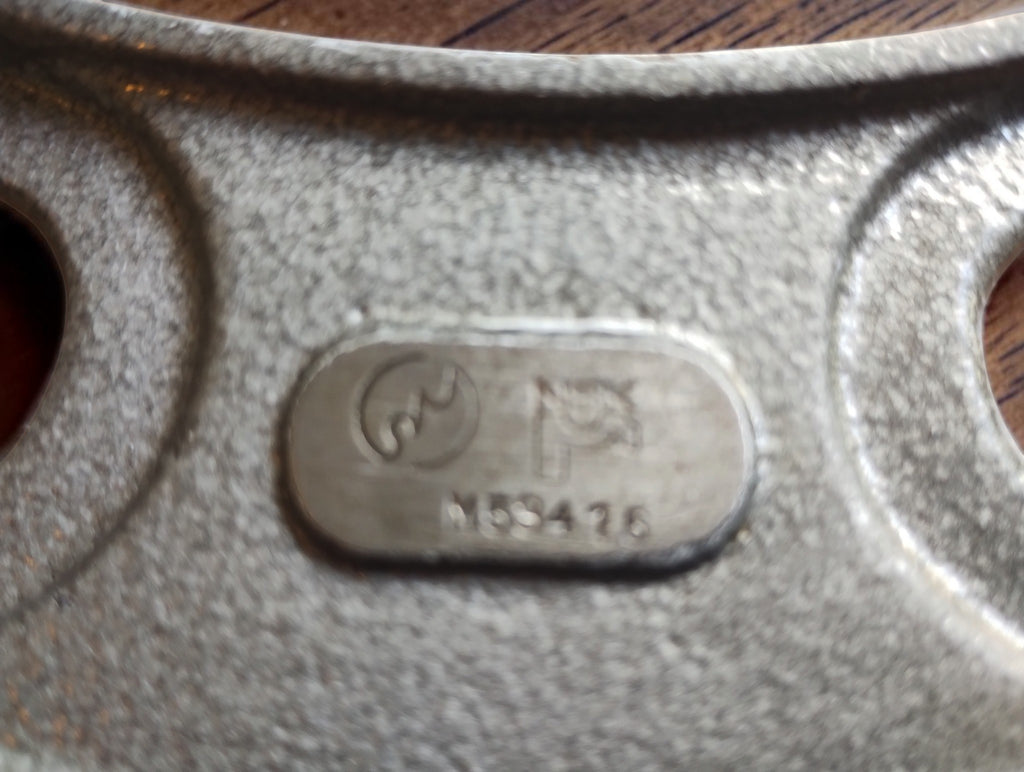 Detail van het NSK-logo en de nummermarkering op het metalen merkplaatje
