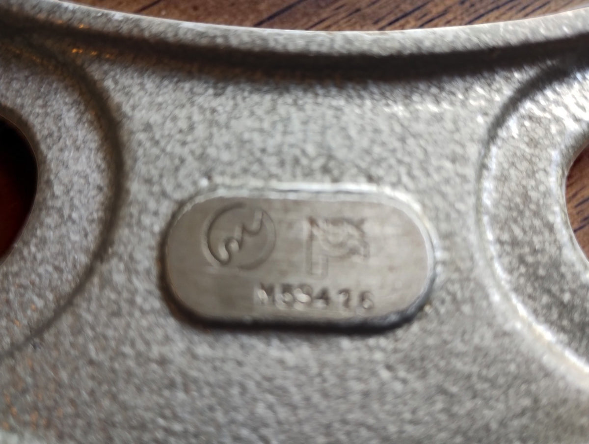 Detail van het NSK-logo en de nummermarkering op het metalen merkplaatje
