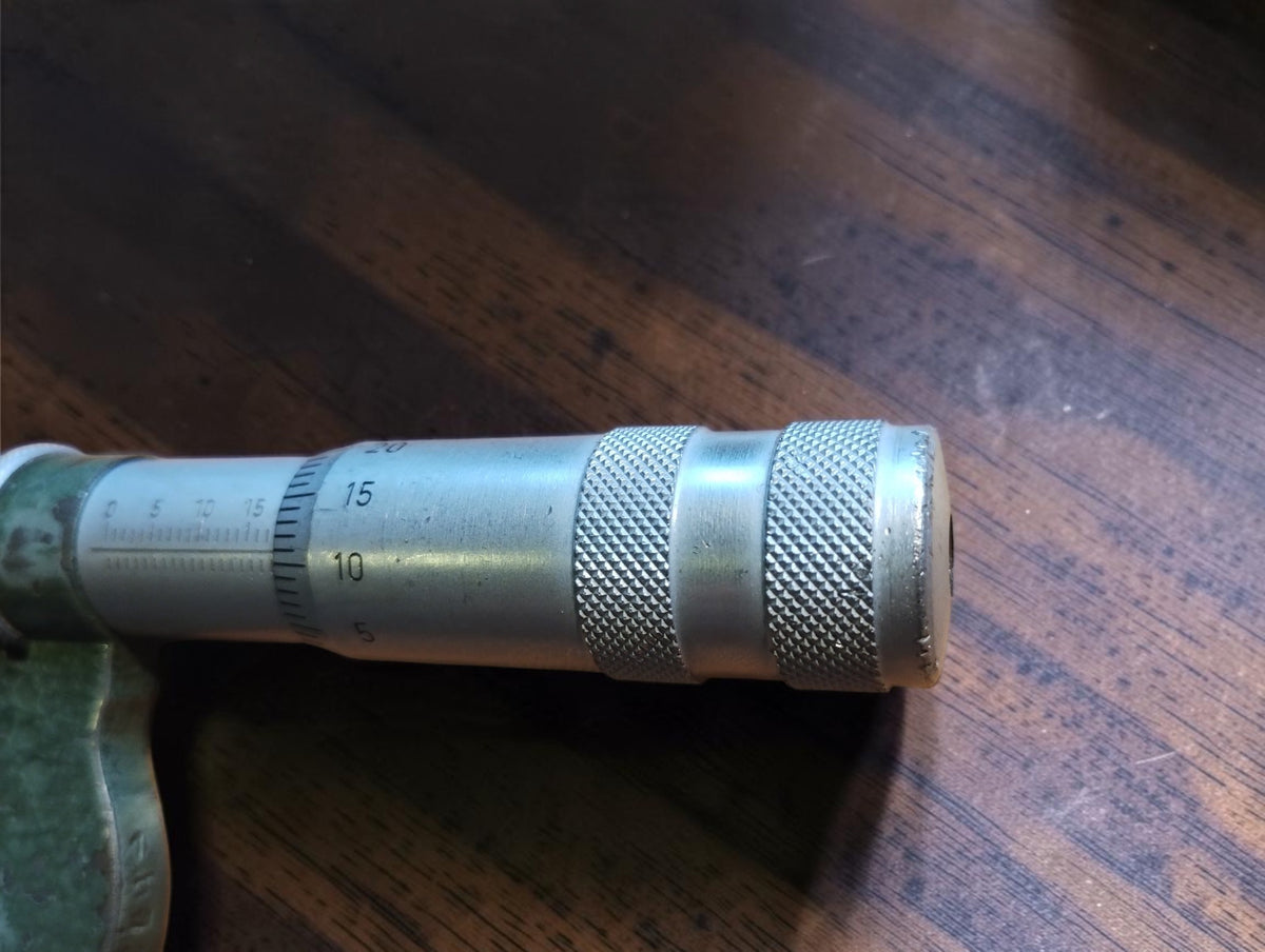Close-up of the micrometer thimble showing two knurled grip sections and numbered graduations
