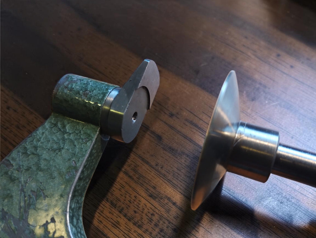 Detail of the disc micrometer measuring faces and visible paint wear on the green frame
