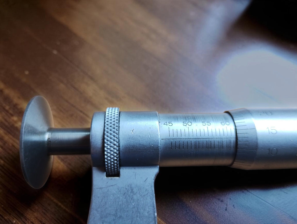 Close-up of the Mahr micrometer scale, knurled locking ring and spindle with a disc-shaped measuring face.
