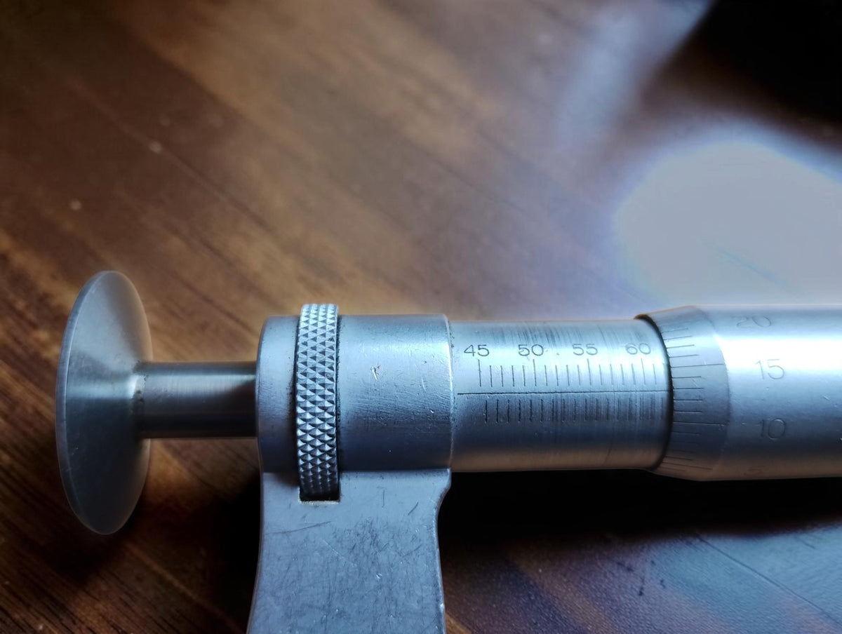 Close-up of the Mahr micrometer scale, knurled locking ring and spindle with a disc-shaped measuring face.
