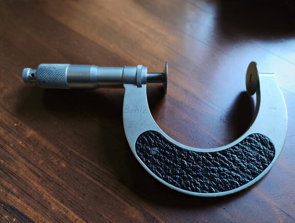 Rear view of the Mahr disc micrometer showing black grip panels and an engraved name on the frame.
