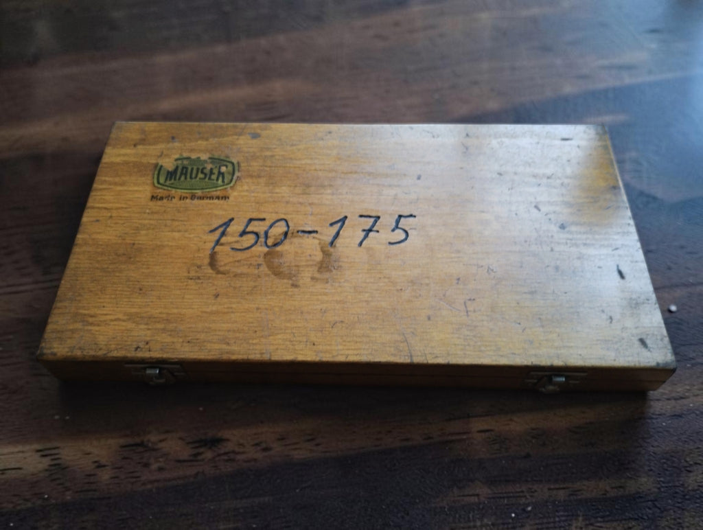 Closed wooden Mauser micrometer case with a worn brand label and handwritten 150–175 marking.
