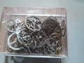 Three open clear boxes with lids displaying assorted vintage watch movement parts, balance wheels and gears.
